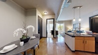 Located at 4400 W Spruce St in Tampa, FL, this well-appointed 2-bedroom, 2-bathroom residence offers a thoughtfully designed single-floor layout with a blend of urban-industrial and contemporary style. Striking polished concrete floors flow through the open-concept living, dining, and kitchen areas, reflecting light and lending a sleek, modern ambiance throughout.

The kitchen is a standout feature, showcasing a large island with dark granite countertops and a double sink, light wood cabinetry reaching toward the ceiling, a tiled backsplash, stainless steel appliances, and stylish pendant lighting. Exposed ductwork adds an industrial touch. The adjacent living room is filled with natural light from floor-to-ceiling sliding glass doors that open onto a private balcony overlooking lush greenery.

The spacious primary bedroom is carpeted for comfort and features generous natural light from large windows. Both bedrooms are served by dedicated closets equipped with multi-tier wire shelving systems, providing ample storage. The primary bathroom offers a dual-sink vanity with dark countertops, light wood cabinetry, and tile flooring. A second well-appointed bathroom serves the additional bedroom. The dining area completes this functional and stylish home.