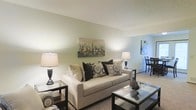 Located at 699 Wellingshire Blvd in Worthington, Ohio, this three-story property presents a thoughtfully designed interior with a clean, neutral color palette that creates a calm and inviting atmosphere throughout. The living area is a central highlight, featuring plush carpeting, soft sage-toned walls, and an open flow that connects seamlessly to the dining area. The space is well-lit with a combination of ambient and accent lighting, giving the room a warm and comfortable feel. Tasteful décor, including contemporary artwork and coordinated furnishings, enhances the overall aesthetic. The open sightline from the living room into the dining area allows for an easy, functional layout suited to both everyday living and entertaining. The neutral tones of the walls and flooring provide a versatile backdrop that adapts well to a variety of interior styles. Spread across three floors, the property offers generous vertical living space, providing ample room for a variety of uses across its levels. This Worthington location places residents within reach of the area's well-regarded amenities, schools, and community resources, making it a practical and appealing choice for those seeking comfortable living in central Ohio.