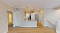 Located at 5815 Garden Village Ct in Greensboro, NC, this single-floor residence offers a thoughtfully designed open-concept layout that seamlessly connects the living, dining, and kitchen areas. Crown molding and light hardwood-style flooring run throughout the main living spaces, creating a cohesive and clean aesthetic.

The kitchen is a standout feature, equipped with granite countertops, white shaker-style cabinetry with modern hardware, stainless steel appliances including a gas range and built-in microwave, and a double-basin sink. A peninsula with pendant lighting above provides an inviting transition into the living area, which benefits from abundant natural light through multiple windows and access to an outdoor area via a glazed door. Ceiling fans are present throughout, enhancing comfort year-round.

The primary bathroom features a dual-sink vanity with dark cabinetry and granite countertops, with light hardwood-style flooring extending throughout. A secondary bathroom includes a tiled shower-tub combination with brushed nickel fixtures. Bedroom spaces are carpeted and generously sized, each with ceiling fans and ample natural light. A dedicated utility area houses a tankless Rheem water heater, reflecting an energy-efficient design. The overall ambiance is bright, neutral, and move-in ready.
