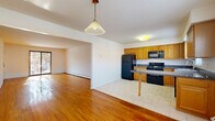 Located at 32 Cedar Ln in Highland Park, NJ, this renovated two-bedroom, two-bathroom home offers a thoughtfully designed single-floor layout. Gleaming hardwood floors run throughout the main living areas, lending warmth and continuity to the space. The open-concept living and dining area flows seamlessly into the kitchen, which is well-appointed with honey-toned wood cabinetry, dark granite countertops, a peninsula with a breakfast bar, and a full suite of black appliances including a gas range, built-in microwave, refrigerator, and dishwasher. Light tile flooring defines the kitchen area, providing a clean contrast to the hardwood. The primary bedroom is generously sized, featuring sliding glass doors that open onto a private balcony with outdoor views, bathing the room in natural light. The second bedroom also offers hardwood floors, a window with natural light, and dedicated closet storage. In total, the unit includes four closets, providing ample storage throughout. The bathrooms are finished with tile flooring, wood vanities, and clean white tile accents. A hallway connects the private quarters to the main living areas, completing this well-organized and move-in ready home.