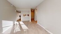 Located at 130 Waverly Way in Carrollton, GA, this single-floor, 2-bedroom, 2-bathroom residence offers a well-designed layout with a clean, modern aesthetic. Light wood-style flooring runs throughout the home, complemented by neutral warm-gray walls and crisp white trim and doors accented with matte black hardware.

The open living area is bright and inviting, with a wide bank of windows that floods the space with natural light. It connects seamlessly to the kitchen via a pass-through counter, creating an open and functional flow. The kitchen is well-appointed with white shaker-style cabinetry, light countertops, a double-basin sink with a matte black faucet, a stainless steel refrigerator, and an electric range.

The primary bedroom is comfortably sized and features two windows that bring in ample natural light, along with a ceiling fan. A dedicated walk-in closet with built-in wire shelving and hanging rods provides practical storage. The second bedroom also benefits from natural light and includes closet access.

Both bathrooms are finished with white vanity cabinetry, light countertops, and matte black fixtures. The primary bath features a stylish vanity mirror framed with black trim and a modern bar light fixture, adding a refined touch to the space.