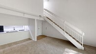 Located at 950 Quail Terrace Ct in Ballwin, MO, this two-story, 3-bedroom, 2-bathroom home offers a well-designed layout spread across two floors. The main level provides a generous living area featuring neutral carpet, soaring vaulted ceilings, and a striking white-railed staircase that adds an open, airy feel to the space. Sliding glass doors on the main level invite natural light and offer views of the surrounding greenery. The galley-style kitchen is thoughtfully updated with white cabinetry, granite-look countertops, black appliances including a range, refrigerator, and dishwasher, and light hardwood-style flooring. Two bathrooms serve the home — one featuring a tiled tub-shower combo and the other a sleek walk-in shower with a sliding glass door and warm wood-tone flooring. The upper level is more intimate in scale, housing the bedrooms, each finished with soft carpet. The spacious primary bedroom benefits from vaulted ceilings, a sliding glass door opening to a balcony with tree-lined views, and abundant natural light. The additional bedrooms feature closets and windows with garden views. Hallways connect each level efficiently, completing a functional and comfortable floor plan.