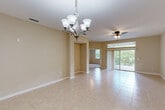 Located at 209 Cantabria Way in Saint Augustine, Florida, this well-appointed single-story residence offers 2 bedrooms and 3 bathrooms within a thoughtfully designed floor plan. The open-concept kitchen, dining, and living area forms the heart of the home, featuring warm wood cabinetry, stainless steel appliances including a refrigerator and range, recessed lighting, and light tile flooring that flows throughout the main living spaces. A decorative chandelier anchors the dining area, which opens toward the living room through an arched passageway. The bedrooms are finished with plush carpeting and ceiling fans, with natural light provided by windows dressed with blinds. The primary bedroom is generously sized, accompanied by a bathroom featuring a glass-enclosed walk-in shower. The additional bathrooms maintain a clean, neutral aesthetic consistent with the rest of the home. A dedicated laundry room houses a full-size washer and dryer. One of the standout features is the spacious covered outdoor balcony, outfitted with a ceiling fan and metal railing, offering serene views of lush Florida greenery including palms and pines — an ideal setting for outdoor relaxation in the Saint Augustine climate.