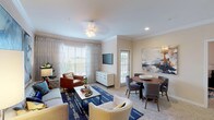 This single-story residence offers two bedrooms and two bathrooms within a thoughtfully designed layout. The open-concept living and dining area serves as the heart of the home, featuring crown molding, recessed lighting, and a ceiling fan. Large windows dressed with sheer curtains and blinds flood the space with natural light while framing outdoor views. The living area provides ample room for generous seating arrangements, while the adjacent dining space accommodates a full-sized table and chairs, ideal for everyday meals or entertaining.

The kitchen is equipped with light wood cabinetry, a coil-burner range, built-in microwave, dishwasher, and continuous countertop workspace, with a pass-through view connecting it to the main living area.

Both bedrooms are carpeted and feature ceiling fans and large windows that bring in natural light. Each bedroom includes walk-in closet space with built-in shelving and hanging rods for organized storage. The two bathrooms each include a tub-shower combination, vanity with countertop space, and wood-style flooring, providing a clean and functional design throughout.