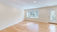 Located at 20 Thornton Road in Brookline, MA, this two-bedroom, one-bathroom residence is thoughtfully organized across two floors. The lower level houses the main living areas, including a combined kitchen and living room, while the upper floor accommodates both bedrooms and the bathroom.

The kitchen is well-appointed with warm maple cabinetry, dark granite countertops, stainless steel appliances including a gas range, microwave, dishwasher, and refrigerator, along with a central island. Light tile flooring and a window provide a bright, functional workspace.

The living areas feature light-toned hardwood floors, crown molding, and recessed lighting throughout. A glass door on the lower level connects to an outdoor area, further enhancing natural light. The upper floor bedrooms each offer hardwood floors, crown molding, and windows framing views of surrounding greenery. The spacious primary bedroom includes a built-in closet with shelving and drawers, while the second bedroom similarly features a walk-in closet with integrated storage.

The bathroom is finished with crisp white subway tile surrounding a soaking tub and shower combination, complemented by a marble-topped vanity and chrome fixtures, creating a clean, classic aesthetic throughout.