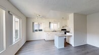 Located at 241 Avocado St in Costa Mesa, California, this single-floor, one-bedroom, one-bathroom home offers a practical and well-organized layout. The open-concept living and kitchen area forms the heart of the home, featuring light wood-look flooring, a textured ceiling, and a ceiling fan that enhances airflow and comfort. Large windows invite generous natural light, creating a bright and airy atmosphere.

The kitchen is well-appointed with crisp white cabinetry, ample upper and lower storage, a double-basin sink, a gas range, a refrigerator, and a peninsula counter that adds extra prep space and defines the transition between the kitchen and living areas. The living room is spacious and open, with a large window overlooking the outdoors.

The bedroom is a comfortable, well-lit room featuring two windows with views of surrounding greenery, wood-look flooring, and a closet. The bathroom includes a wide vanity with a white countertop, an integrated sink, under-sink storage, and dual wall-mounted mirrors.

A hallway connects the main living spaces to the bedroom and bathroom, contributing to a logical and efficient floor plan. Throughout the home, neutral tones, clean finishes, and consistent wood-look flooring create a cohesive and move-in ready aesthetic.