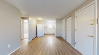 Located at 83 Edbert St in Chicopee, Massachusetts, this single-floor unit offers a clean, updated interior with a cohesive neutral color palette and durable flooring throughout the main living areas. The kitchen is well-appointed with white shaker-style cabinetry, light stone-look countertops, a stainless steel sink, and white appliances including a refrigerator and electric range. A window above the sink allows natural light to brighten the workspace. The kitchen flows openly into the living area, which features light wood-look vinyl plank flooring, soft gray walls, and baseboard heating. Multiple doors in the living space provide access to additional rooms, closet storage, and building exits, offering practical functionality. The bedrooms are carpeted for comfort and include windows that bring in natural light along with baseboard heating units. The full bathroom is finished with wood-look vinyl flooring, a white vanity with under-sink storage, and a full-sized soaking tub with an overhead shower. Throughout the unit, the design is consistent and understated, with white trim, neutral tones, and clean finishes that create a bright, move-in ready environment suited for everyday living.