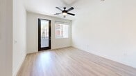 Located at 201 Coolidge St in Phoenix, AZ, this well-appointed one-bedroom, one-bathroom unit offers a thoughtfully designed layout across a single floor. The open-concept kitchen and living area serves as the heart of the home, showcasing light hardwood-style flooring, recessed lighting, and a ceiling fan. The kitchen is a standout feature, boasting bold navy cabinetry with a striking tile backsplash, warm wood lower cabinets, stainless steel appliances including a gas range, built-in microwave, and French door refrigerator, plus a large center island with a white quartz countertop and pendant lighting. A stacked in-unit washer and dryer adds everyday convenience. The living area opens to a private balcony through a frosted-glass door, framing views of the palm tree-lined courtyard. The bedroom is carpeted for comfort and is bathed in natural light through a large window with outdoor views. A ceiling fan completes the cozy atmosphere. The walk-through closet leads to a spacious bathroom featuring dual vessel sinks on a dark vanity with quartz countertops, wood-look tile flooring, and a full soaking tub with a tiled surround. Clean white walls and modern finishes throughout give this unit a crisp, contemporary feel.