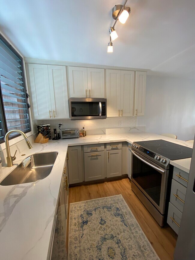 Kitchen with quartz counter tops and stainless steel appliances. - 1015 Aoloa Plz