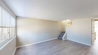 Located at 44 Eagle Ct in Wilkes-Barre, Pennsylvania, this two-story, 1-bedroom, 2-bathroom home offers a well-organized layout spread across two floors. The main level features a living room with light gray luxury vinyl plank flooring, neutral-toned walls with vertical shiplap paneling accents, and a large window that invites natural light. A carpeted staircase leads to the upper level. The kitchen is a functional highlight, featuring warm honey-toned wood cabinetry, stainless steel appliances including a gas range and over-the-range microwave, a double sink, and a standout peninsula with a striking marble-look countertop and slatted wood base — ideal for casual dining or additional prep space. The upper level houses the generously sized primary bedroom, finished with plush carpet, a large louvered double-door closet, and a sliding glass door opening to a private balcony with outdoor views. Two bathrooms serve the home, including one with a full tub and shower combo fitted with chrome fixtures. Throughout the home, clean white trim, consistent neutral tones, and practical finishes create a cohesive and move-in-ready environment suitable for comfortable everyday living.