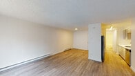 Located at 19605 SW Boones Ferry Rd in Tualatin, Oregon, this single-floor unit offers a clean, functional layout with thoughtfully updated finishes throughout. The open living area features wood-style plank flooring, crisp white walls, a textured ceiling, and baseboard heating running along the perimeter. A large window with vertical blinds allows natural light to fill the space and provides a view of the surrounding exterior. The living area flows toward the kitchen, which is outfitted with gray shaker-style cabinetry, white countertops, a stainless steel undermount sink with a contemporary pull-down faucet, and a dishwasher — offering a modern and practical cooking environment. The bedroom is carpeted in a neutral gray tone and includes a ceiling fan, a baseboard heater, and a window with vertical blinds that brings in additional natural light. The bathroom is finished in a bright, all-white palette with wood-style flooring, a tub-shower combination, a white vanity with brushed gold hardware, and a wall-mounted mirror. Throughout the unit, the consistent use of neutral tones and updated fixtures creates a cohesive, move-in-ready living environment well-suited for everyday comfort.