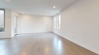 Located on Elmwood Avenue in Buffalo's vibrant Elmwood Village neighborhood, this modern 2-bedroom, 3-bathroom residence offers a thoughtfully designed single-floor layout with clean lines and contemporary finishes throughout. Light-toned hardwood floors flow seamlessly across the entire living space, complementing the bright, white walls and recessed lighting that give the home an open, airy feel.

The open-concept kitchen and living area serves as the heart of the home. The kitchen is equipped with stainless steel appliances, light wood cabinetry extending to the ceiling for ample storage, and a sleek center island with a dark quartz countertop and an integrated sink. A sculptural pendant light anchors the island, adding a modern design touch. Large windows allow natural light to fill both the kitchen and the adjacent living area.

The generously sized primary bedroom offers a sliding double-door closet, natural light from nearby windows, and a ceiling fan. The second bedroom is also well-proportioned with dual windows framing outdoor views and its own closet. Three bathrooms serve the residence, including a spa-inspired shower clad in large-format neutral tiles with built-in black corner shelving, and a clean, tile-floored powder room with a floating vanity. The overall ambiance is modern, minimal, and move-in ready.
