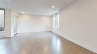 Located on Elmwood Avenue in Buffalo's vibrant Elmwood Village neighborhood, this modern 2-bedroom, 3-bathroom residence offers a thoughtfully designed single-floor layout with clean lines and contemporary finishes throughout. Light-toned hardwood floors flow seamlessly across the entire living space, complementing the bright, white walls and recessed lighting that give the home an open, airy feel.

The open-concept kitchen and living area serves as the heart of the home. The kitchen is equipped with stainless steel appliances, light wood cabinetry extending to the ceiling for ample storage, and a sleek center island with a dark quartz countertop and an integrated sink. A sculptural pendant light anchors the island, adding a modern design touch. Large windows allow natural light to fill both the kitchen and the adjacent living area.

The generously sized primary bedroom offers a sliding double-door closet, natural light from nearby windows, and a ceiling fan. The second bedroom is also well-proportioned with dual windows framing outdoor views and its own closet. Three bathrooms serve the residence, including a spa-inspired shower clad in large-format neutral tiles with built-in black corner shelving, and a clean, tile-floored powder room with a floating vanity. The overall ambiance is modern, minimal, and move-in ready.