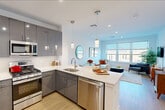 Located at 620 Bloomfield Avenue in Bloomfield, NJ, this thoughtfully designed one-bedroom, one-bathroom residence offers a modern open-concept layout with clean lines and contemporary finishes throughout. Light wood-style flooring flows seamlessly across the entire unit, lending warmth and continuity to every room.

The kitchen is a standout feature, showcasing high-gloss gray cabinetry, white quartz countertops, a subway tile backsplash, and a full suite of stainless steel appliances including a gas range, built-in microwave, dishwasher, and French door refrigerator. A peninsula with pendant lighting connects the kitchen to the dining area, creating a natural hub for entertaining. The open living room is bright and inviting, with large windows framing views of the surrounding Bloomfield streetscape.

The bedroom offers a comfortable, well-proportioned retreat with a large window providing ample natural light and outdoor views. It is complemented by a spacious walk-in closet with wire shelving on multiple walls for generous storage.

The bathroom is finished in crisp whites with a wide vanity, large mirror, and a glass-enclosed shower. A stacked washer and dryer unit is conveniently located within the bathroom, adding practical in-unit laundry access. Recessed lighting throughout enhances the bright, airy ambiance of this well-appointed residence.