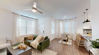 Located at 370 Homestead Ave in Greenwood, Indiana, this single-floor residence offers 2 bedrooms and 2 bathrooms within a thoughtfully designed layout. The open-concept living and dining area is bright and welcoming, featuring wood-look flooring, crisp white walls, a modern ceiling fan, and multiple windows dressed with sheer curtains and blinds that flood the space with natural light. The kitchen is well-equipped with white shaker cabinetry, a gray tile backsplash, stainless steel appliances, a peninsula with bar seating, and pendant lighting — ideal for both cooking and casual dining. The generously sized primary bedroom features plush carpeting, a ceiling fan, and a large window with outdoor views, complemented by a walk-in closet with built-in shelving. The second bedroom is equally comfortable with carpet flooring and natural light. Both bathrooms are finished with wood-look flooring, and the primary bath features a dual-sink vanity with stone countertops and a frameless glass shower with marble-style tile. A dedicated laundry room with a full-size washer and dryer adds everyday convenience. The space combines clean, modern aesthetics with practical amenities throughout.