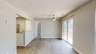 Located at 1402 Club Pkwy in Norcross, GA, this well-appointed one-bedroom, one-bathroom unit offers a thoughtfully designed single-floor layout. The living room is bright and welcoming, featuring wood-look plank flooring, neutral warm-toned walls, a textured ceiling, and a ceiling fan with light fixture. Multiple windows flood the space with natural light, while a sliding glass door provides direct access to an outdoor area. The kitchen is cleanly designed with crisp white shaker cabinets, white subway tile backsplash, light countertops, and stainless steel appliances including a gas range and full-size refrigerator. A pass-through counter connects the kitchen to the living area, enhancing the open feel. The bedroom offers plush carpeting, a natural light-admitting window with blinds, and access to a generous walk-in closet outfitted with wire shelving and hanging rods. The bathroom features a full tub-shower combo with white tile surround, a vanity with storage, and wood-look flooring. Throughout the unit, clean finishes and a neutral color palette create a cohesive and functional living environment.