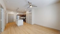 This well-appointed one-bedroom, two-bathroom residence in San Antonio, TX offers a thoughtfully designed single-story layout. The open-concept living area seamlessly connects the kitchen and living room, creating an airy and functional space. Light hardwood flooring flows throughout the main areas, complemented by a ceiling fan that enhances airflow and comfort.

The kitchen is a standout feature, anchored by a large central island with granite countertops and an integrated sink, illuminated by a trio of elegant pendant lights. Dark espresso cabinetry provides generous storage, while a full suite of stainless steel appliances — including a refrigerator, electric range, microwave, and dishwasher — completes the space. A pantry and dedicated laundry room add everyday convenience.

The bedroom is carpeted for comfort, features natural light through dual windows, and includes a ceiling fan. Two closets offer ample storage. Both bathrooms are finished with granite-topped vanities, dark cabinetry, and light hardwood flooring; one includes a full soaking tub with a tiled surround. A hallway connects the private and shared areas efficiently. The overall aesthetic is clean and modern, with a neutral palette that creates a bright, welcoming atmosphere throughout.
