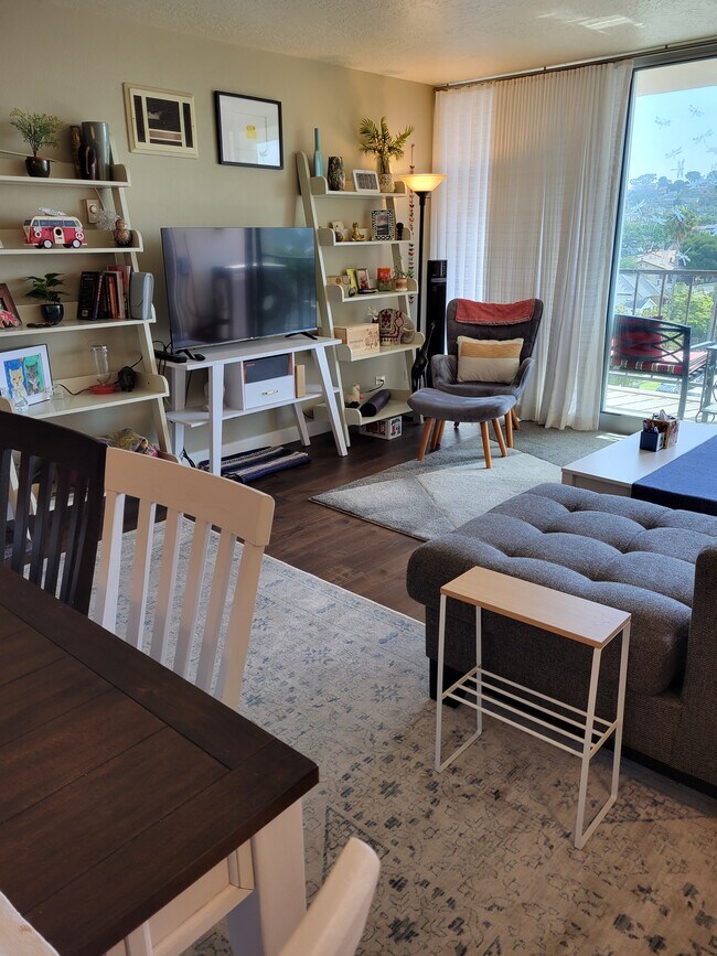 Open plan kitchen, dining, and living room with full-slide floor-to-ceiling doors leading to balcony - 4944 Cass St