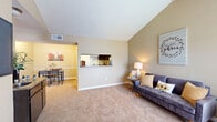 Located at 3700 Watonga Blvd in Houston, TX, this 2-bedroom, 2-bathroom single-floor residence offers a functional and comfortable layout with thoughtful design details throughout. The living room is a standout space, featuring dramatic vaulted ceilings that lend an open, airy feel, complemented by neutral carpet flooring and warm-toned walls. A pass-through window connects the living area to the kitchen, enhancing the sense of openness while maintaining a defined layout. The adjacent dining area provides a cozy, dedicated space for meals. The kitchen features dark cabinetry with tile backsplash accents. Both bedrooms are carpeted and include ceiling fans, ample closet space, and windows that allow natural light to filter in. The spacious primary bedroom offers a generous footprint with room for full-sized furnishings. The second bedroom is well-suited for various uses. Both bathrooms feature hardwood-style flooring, with one showcasing a dark vanity with stone-look countertops and a mirrored medicine cabinet. A hallway connects the bedrooms and bathrooms, with three closets distributed throughout the unit for added storage. The overall ambiance is warm, neutral, and move-in ready.