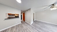 This single-story home offers a practical and well-organized layout across three bedrooms, two bathrooms, a living room, kitchen, hallway, and closet. The living area welcomes you with light gray wood-look vinyl flooring and neutral-toned walls, creating a clean, airy atmosphere. A ceiling fan adds comfort, and a front-facing window allows natural light to fill the space. The kitchen is efficiently designed with warm wood cabinetry, dark granite-style countertops, a mosaic tile backsplash, and black appliances including a range and refrigerator. A pass-through window connects the kitchen to the living area, enhancing the open feel. The bedrooms feature light beige tile flooring and ceiling fans with light fixtures, each offering a functional, straightforward layout. One bedroom benefits from a window with exterior views, adding natural light. The bathrooms are finished with tile-surround tub-shower combinations and wood-look vinyl flooring, providing a clean, utilitarian design. A hallway connects the rooms efficiently, and a dedicated closet offers additional storage. Throughout, the neutral color palette and consistent flooring choices create a cohesive, move-in-ready environment suited for a variety of living arrangements.