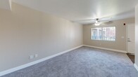 Located at 3939 Cranford Ave in Riverside, CA, this unit offers a well-organized single-floor layout comprising three bedrooms, two bathrooms, a kitchen, and a hallway. The living areas are finished with soft gray carpeting throughout, complemented by warm beige walls and clean white baseboards that create a neutral, move-in-ready aesthetic. A ceiling fan with a light fixture is installed in the main living area, which also features a window that allows natural light to fill the space. The spacious primary bedroom is a standout feature, offering a sliding glass door that opens directly to a private balcony with outdoor views of surrounding greenery and a pool area, along with a sliding double-door closet for ample storage. Additional bedrooms also feature carpeted flooring and windows that invite natural light. The kitchen is fitted with white cabinetry, light speckled countertops, a double-basin sink, and wood-look vinyl flooring, providing a clean and functional cooking space with a skylight overhead. The two bathrooms include updated vanities with light stone-style countertops, large mirrors with overhead lighting, and wood-look flooring. One bathroom features a glass-door walk-in shower with chrome fixtures, adding a polished touch to the space.