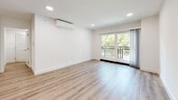 Located at 730 S Kingsley Dr in the heart of Los Angeles, this well-appointed 2-bedroom, 2-bathroom unit offers a clean, modern aesthetic throughout. Light wood-tone flooring runs continuously across the entire space, complementing the crisp white walls and recessed lighting that create a bright, airy atmosphere.

The open-concept layout seamlessly connects the living room, dining area, and kitchen. The kitchen is outfitted with stainless steel appliances — including a gas range, built-in microwave, dishwasher, and refrigerator — paired with white shaker cabinetry and light countertops. A wall-mounted mini-split HVAC unit ensures year-round comfort in the living area, which opens to a balcony framed by lush tree views through sliding glass doors.

The spacious primary bedroom features a large window overlooking greenery, providing ample natural light. The second bedroom also benefits from a generous window with neighborhood views. Three closets offer plentiful storage throughout the unit.

Both bathrooms maintain the home's clean design with white vanities, quartz-style countertops, and tub-shower combinations with glass enclosures. A dedicated laundry area and a connecting hallway complete the thoughtfully designed floor plan, making this residence a comfortable and functional home in a prime Los Angeles location.
