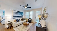 Located at 500 Verdant Way in Charleston, SC, this well-appointed two-bedroom, two-bathroom residence offers a thoughtfully designed single-level layout with hardwood-style flooring throughout. The open-concept kitchen and living area serves as the heart of the home, featuring a modern kitchen outfitted with white shaker cabinetry, stainless steel appliances, a subway tile backsplash, a pantry, and a breakfast bar with seating. The adjacent living room is bright and welcoming, with natural light pouring in through large windows and a glass door that opens to an outdoor balcony, complemented by a ceiling fan overhead. The primary bedroom is a comfortable retreat, offering a ceiling fan, ample natural light from large windows, direct access to an en-suite bathroom, and a spacious walk-in closet with wire shelving. The second bedroom is equally well-lit. Both bathrooms are finished with white vanities, dark hardware accents, and tub-shower combinations with tile surrounds. A dedicated in-unit laundry room houses a full-size washer and dryer. With five closets total and a pantry, storage is abundant throughout. The clean, neutral palette and consistent flooring create a cohesive and modern ambiance across the entire home.
