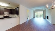 This 2-bedroom, 2-bathroom residence at 675 Tea St in Bound Brook, NJ delivers a generous and well-appointed single-floor layout. The open-concept living area is anchored by rich hardwood flooring, a sleek wall-mounted fireplace, and expansive sliding glass doors that open to a private balcony overlooking lush greenery, flooding the space with natural light. The kitchen features dark espresso cabinetry, granite countertops, a classic subway tile backsplash, stainless steel appliances including a gas range, microwave, and refrigerator, and a distinctive checkered tile floor. An in-unit laundry area is conveniently tucked just off the kitchen. The two bedrooms offer plush carpeting and bright windows with outdoor views, providing a calm and comfortable retreat. The primary bathroom includes a dual-sink vanity with dark cabinetry, a soaking tub, and a separate glass-enclosed walk-in shower with tile surround. The second bathroom mirrors the same refined aesthetic with a tiled tub-shower combo and a single vanity. Throughout the residence, neutral tones and clean lines create a cohesive, modern ambiance well-suited for comfortable everyday living.