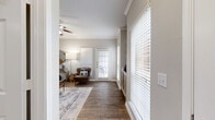This single-story 2-bedroom, 2-bathroom residence offers a thoughtfully designed layout that balances comfort and functionality. The open-concept living room greets you with rich hardwood-style flooring, crown molding, a ceiling fan, and multiple windows dressed with horizontal blinds that invite generous natural light. A glass-panel door leads to an outdoor area, enhancing the bright, airy atmosphere. Built-in shelving adds both character and practical storage to the living space.

The kitchen is a standout feature, showcasing white shaker cabinetry, granite countertops, a tile backsplash, and a peninsula with seating for two — ideal for casual dining or entertaining. Stainless steel appliances, including a gas range, microwave, and refrigerator, complete the space.

The spacious primary bedroom is finished with plush carpeting, a ceiling fan, and a window that allows natural light to filter in, while providing access to its own private ensuite bathroom. The second bedroom is equally comfortable, also featuring carpet flooring and a ceiling fan. Both bathrooms are clean and functional, with white cabinetry and tub-shower combinations.

A dedicated in-unit laundry room with overhead cabinetry adds everyday convenience, and three closets throughout the home provide ample storage. The neutral gray-toned palette and consistent finishes create a cohesive, modern aesthetic throughout.