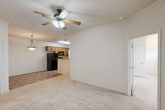 Located at 2118 W Old Spanish Trl in New Iberia, Louisiana, this two-story, three-bedroom, two-bathroom home offers a well-organized and functional layout across two levels. The main living area is open and airy, with soft carpet underfoot and a ceiling fan overhead. It flows seamlessly into a combined kitchen and dining space, where warm wood cabinetry, granite-style countertops, tile flooring, and black appliances create a practical and cohesive kitchen. Pendant lighting accents the dining area, adding warmth to the open-concept design. Crown molding in the living and entry areas adds a refined touch throughout.

Carpeted staircases with dual handrails connect the floors, leading to the upper level where all three bedrooms are situated. Each bedroom features plush carpet, ceiling fans, and natural light from windows with blinds. The spacious primary bedroom includes its own closet with wire shelving. Additional closets throughout the home provide ample storage. The bathrooms are finished with tile flooring, oak-toned vanity cabinetry, and tub-shower combinations. A dedicated laundry room with utility hookups rounds out the home's practical amenities, making this a complete and move-in-ready residence.