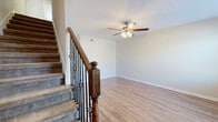 Located at 2190 W Allen Griffey Rd in Clarksville, TN, this two-story home offers 2 bedrooms and 2 bathrooms thoughtfully distributed across two floors. The main level features an open kitchen and living area with light hardwood-style flooring and recessed lighting. The kitchen is appointed with rich dark cabinetry, granite-style countertops, a subway tile backsplash, and stainless steel appliances including a refrigerator, electric range, over-the-range microwave, and dishwasher. Natural light pours in through multiple windows, and a door provides convenient exterior access. A staircase with a handsome wood and wrought iron railing leads to the upper level. The living room is bright and open, with a ceiling fan and hardwood-style flooring. Upstairs, both bedrooms are carpeted and equipped with ceiling fans; the primary bedroom offers generous proportions and natural light from a large window. The bathrooms are cleanly finished, with one featuring stone-look tile flooring, a dark wood vanity with white countertop, and a tub/shower combo. A utility room and closet round out the functional layout of this well-appointed Clarksville home.