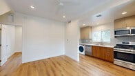 This 440 square foot apartment in Los Angeles offers a thoughtful blend of style and functionality. The single-floor layout comprises one bedroom, one bathroom, and an open-concept living area. The kitchen is a standout feature, boasting modern stainless steel appliances, including a gas range, refrigerator, and built-in microwave. The two-tone cabinetry combines sleek upper cabinets with warm wood lower units, complemented by a subtle blue-gray tile backsplash and quartz countertops.

The 130 square foot bedroom provides ample space and features a large window for natural light. The bathroom showcases a striking blue vanity with a marble-look countertop, adding a pop of color to the neutral palette. Throughout the apartment, warm wood-look flooring creates a cohesive and inviting atmosphere. The space is further enhanced by recessed lighting and a ceiling fan in the bedroom for added comfort. Large windows in the living area and bedroom offer views of the surrounding greenery, creating a connection to the outdoors. This efficiently designed apartment maximizes every square foot, providing a comfortable and stylish living space in the heart of Los Angeles.