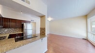 Located at 2901 Euclid Ave NE in Albuquerque, New Mexico, this well-appointed 2-bedroom, 2-bathroom residence offers a comfortable and functional single-floor layout. Warm hardwood-style flooring flows throughout, creating a cohesive and inviting atmosphere across all rooms.

The combined kitchen and living area serves as the heart of the home. The kitchen is outfitted with rich dark-wood cabinetry, granite countertops, a decorative tile backsplash, and a full suite of stainless steel appliances including a refrigerator, dishwasher, and range. A breakfast bar with a granite overhang opens directly to the living room, enhancing the open-concept feel. The living room is bright and airy, benefiting from expansive windows that invite abundant natural light and offer views of the surrounding area.

The spacious primary bedroom features a sliding glass door that opens to a private balcony, providing additional outdoor access and natural light. The second bedroom is also generously sized with a large window overlooking greenery. Both bathrooms are finished with neutral tile work — one featuring a glass-enclosed walk-in shower, the other a full soaking tub with floor-to-ceiling tile surround. A connecting hallway ties all rooms together efficiently, completing this well-designed residence.