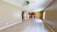 This single-story, 2-bedroom, 1-bathroom home offers a practical and functional layout across a comfortable footprint. The open-concept main living area seamlessly connects to the kitchen and dining space, creating a welcoming, communal atmosphere. Light ceramic tile flooring runs throughout the home, providing a clean and cohesive look. The living area features vaulted ceilings with a ceiling fan and light fixture, enhancing the sense of openness, while warm golden-tan walls lend a cozy ambiance. Large windows allow natural light to fill the space.

The kitchen is well-appointed with solid wood cabinetry in a warm honey-oak finish, a tile backsplash, and a standout custom wood range hood that serves as a focal point. A built-in wine rack above the refrigerator adds a distinctive touch. White appliances, including a range and refrigerator, complete the space.

Both bedrooms continue the tile flooring and warm wall tones, each equipped with ceiling fans and windows that bring in natural light. The primary bedroom offers a generously sized layout. The full bathroom includes a single-sink vanity, toilet, and a shower-tub combination. A dedicated closet provides additional storage, rounding out the home's efficient and well-organized floor plan.