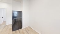 Located on S King Dr in Chicago's Woodlawn neighborhood, this single-floor unit offers three bedrooms, one bathroom, a kitchen, living room, hallway, and two closets in a practical and efficiently arranged layout. The interior features a clean, neutral palette with bright white walls throughout, creating a fresh and airy atmosphere. Light wood-style luxury vinyl plank flooring runs through the main living areas and kitchen, while the bedrooms are fitted with warm, tan carpet for added comfort. The kitchen is well-appointed with white cabinetry, dark countertops, a black gas range, a stainless steel sink, and a full-size refrigerator, along with a window and direct exterior door access. The bedrooms are generously proportioned relative to the overall footprint, with two rooms featuring windows with natural light and classic cast-iron radiators that provide radiant heat. The bathroom is finished with light tile flooring, a white vanity with a sink, a mirror, and overhead lighting. Two closets provide dedicated storage within the unit. The overall design is clean and functional, offering a move-in-ready living environment in a well-connected Chicago neighborhood.
