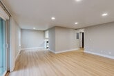 Located in Bellevue, WA, this two-bedroom, one-bathroom residence offers a thoughtfully designed single-floor layout finished with light-toned hardwood flooring and a neutral color palette that creates a bright, cohesive atmosphere throughout.

The open living area is a standout feature, bathed in natural light from large sliding glass doors that lead to a private balcony overlooking mature trees and lush Pacific Northwest greenery. Recessed lighting complements the natural light, while baseboard heating ensures year-round comfort. The living space flows seamlessly toward the kitchen, which is equipped with stainless steel appliances and white cabinetry.

Both bedrooms are well-proportioned and feature sliding closet doors for efficient storage. The primary bedroom is generously sized and includes a window for natural light. The second bedroom also benefits from a window and closet access. The hallways connecting the rooms are clean and functional, maintaining the home's open feel.

The bathroom is finished with a white vanity, single-basin sink, a tub-shower combination, and light wood-style flooring that ties in with the rest of the home. Textured walls and clean white trim throughout add subtle character to the overall design, making this a comfortable and move-in-ready residence.