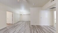Located at 518 Fabra St in Boerne, TX, this single-story 2-bedroom, 3-bathroom home offers a clean, bright, and functional layout. Light-toned wood-style flooring runs consistently throughout, creating a cohesive and easy-to-maintain interior. The open living area features soaring vaulted ceilings with a pendant light fixture, lending an airy sense of spaciousness. A ceiling fan is present in the main living space, as well as in both bedrooms, supporting year-round comfort. The kitchen is efficiently designed in a galley style, equipped with white appliances including a range, dishwasher, refrigerator, and built-in microwave, complemented by gray laminate countertops and cream cabinetry with ample upper and lower storage. Track lighting illuminates the kitchen area. The primary bedroom is generously sized with a large window that allows natural light to fill the room and includes a double-door closet. The second bedroom also features a ceiling fan and a large window. The bathrooms are thoughtfully designed with accessible features, including grab bars and open under-sink vanities, along with mirrored medicine cabinets. The overall aesthetic is neutral and modern, with white walls and clean finishes throughout.