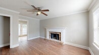 Located at 3661 Airport Blvd in Mobile, Alabama, this two-floor home offers a well-considered layout spread across two levels. The main floor centers around a welcoming living room highlighted by a classic brick fireplace with an elegant white-painted mantel, warm hardwood flooring, crown molding, and a ceiling fan — all contributing to a comfortable and inviting atmosphere. Natural light filters in through multiple windows, enhancing the neutral, soft-toned walls throughout.

The kitchen features white cabinetry, subway tile backsplash, light stone countertops, stainless steel appliances including an electric range and dishwasher, and tile flooring. A window above the sink brings in natural light and outdoor views.

Upstairs, the spacious primary bedroom is generously sized, finished with plush carpeting, crown molding, a ceiling fan, and multiple windows that fill the room with natural light. Three closets are distributed throughout the home, providing ample storage. Two full bathrooms include clean, tiled finishes with a tub/shower combination. A staircase connects the two floors, and a hallway provides organized circulation throughout the upper level.