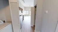 Located at 970 Riverside Forest Way in Knoxville, TN, this 2-bedroom, 2-bathroom residence offers a thoughtfully designed single-floor layout with an efficient use of space. The open kitchen is a standout feature, showcasing rich dark wood cabinetry, dark granite countertops, a classic white subway tile backsplash, and a full suite of stainless steel appliances including a refrigerator, range, microwave, and dishwasher. Track lighting overhead adds a modern touch, while the soaring ceilings lend an airy, expansive feel to the living and kitchen areas. Light hardwood-style flooring flows throughout the main living spaces, complementing the bright, neutral color palette. Both bedrooms are carpeted and feature impressively tall ceilings, large windows that invite natural light, and views of the surrounding area. The spacious primary bedroom includes a dedicated closet. Each bathroom is finished with dark wood vanities, light hardwood-style flooring, and clean white fixtures. One bathroom features a full soaking tub and shower combination, while both bathrooms maintain a consistent, modern aesthetic. The overall ambiance is clean, contemporary, and move-in ready.
