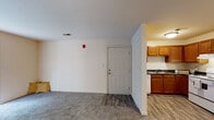 Located at 8 Covey Ln in Greensboro, NC, this single-floor unit offers a practical and well-organized layout suited for comfortable everyday living. The entry opens into a combined living and dining area, where durable wood-look flooring transitions seamlessly into plush carpeting, defining the distinct zones of the space. The living area is bright and open, with neutral walls and a window that welcomes natural light and views of surrounding greenery, creating a calm and inviting atmosphere.

Adjacent to the entryway, the kitchen is efficiently designed with warm-toned wooden cabinetry, dark granite-style countertops, and white appliances including a refrigerator, range, dishwasher, and under-cabinet range hood. The wood-look flooring continues throughout the kitchen, adding cohesion to the space.

The bedroom is generously sized, finished with soft carpeting and a window that provides ample natural light and outdoor views. A closet is accessible from within the room, offering practical storage solutions.

The bathroom features wood-look tile flooring, a shower-tub combination, and brushed nickel hardware and towel bars, contributing a clean and functional aesthetic. Throughout the unit, neutral tones and consistent finishes create a cohesive, move-in-ready environment.