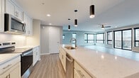 Located at 2430 W Seventh St in Cleveland's vibrant Ohio City neighborhood, this contemporary single-floor residence offers three bedrooms and four bathrooms across a generously sized, thoughtfully designed floor plan. The open-concept kitchen and living area serves as the heart of the home, featuring white shaker cabinetry, quartz countertops, stainless steel appliances, a large center island with an undermount sink, and stylish pendant lighting. Wood-look luxury vinyl plank flooring flows throughout the main living areas, while black-framed windows invite abundant natural light and urban views. The spacious living room provides ample room for entertaining. Each bedroom is carpeted for comfort, with the well-proportioned primary suite offering generous closet space complete with wire shelving systems. The bathrooms are finished with marble-look tile flooring, dark vanity cabinetry, and white quartz countertops with brushed nickel fixtures. A dedicated laundry room accommodates a full-size washer and dryer beneath a built-in dark stone folding counter. Two closets and a clean, neutral color palette throughout complete this polished, move-in-ready residence.
