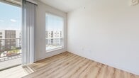 Located at 1150 N Price Rd in Saint Louis, MO, this thoughtfully designed 3-bedroom, 2-bathroom unit offers a clean, modern aesthetic across a single floor. The open-concept kitchen and living area serves as the heart of the home, where light wood-look flooring flows seamlessly throughout. The kitchen is outfitted with crisp white shaker cabinetry, a subway tile backsplash, stainless steel appliances, and a large island with a dark stone countertop — ideal for both meal prep and casual dining. The living area connects directly to a private balcony through a sliding glass door, providing outdoor access and natural light. The three bedrooms feature plush carpeting and ceiling fans, with windows dressed in blinds that invite ample daylight and outdoor views. The primary bedroom includes a spacious walk-in closet with wire shelving. Both bathrooms are finished with warm wood vanities, dark stone countertops, and black hardware accents — one featuring a tub-shower combo. A dedicated laundry room houses a stacked washer and dryer unit with additional shelving. The overall ambiance is bright, clean, and contemporary, reflecting a well-appointed modern living space.