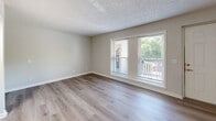 This single-story, 3-bedroom, 2-bathroom home in Nashville, Tennessee offers a clean, updated interior with a practical and well-organized layout. Throughout the home, light wood-look flooring and neutral-toned walls create a bright, cohesive atmosphere, complemented by textured ceilings and crisp white trim.

The living room is generously proportioned, featuring large windows with blinds that allow abundant natural light to pour in, along with a ceiling fan overhead. Adjacent spaces include a dedicated dining room and a galley-style kitchen outfitted with white shaker cabinetry, light countertops, black appliances including a refrigerator and electric range, and a ventilation hood — all set atop matching wood-look flooring.

The primary bedroom offers comfortable square footage with a closet and direct access to the hallway. The two additional bedrooms are bright and well-sized, each with windows providing natural light and views of the surrounding greenery. Closet storage is available throughout the home.

Both bathrooms are finished with white vanity cabinetry, light countertops, large framed mirrors, subway tile shower surrounds, and chrome fixtures, presenting a clean and modern aesthetic. A utility room and two hallways round out the home's complete and functional floor plan.
