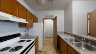 Located at 4551 Durrow Dr in Columbus, Ohio, this single-floor unit offers a practical and functional layout designed for comfortable everyday living. The open living and dining area is finished with neutral carpet and tile flooring, with a pendant light fixture overhead and a window that brings in natural light. A peninsula counter connects the living space to the kitchen, creating an open flow between the two areas.

The galley-style kitchen is efficiently arranged with warm wood cabinetry lining both sides, offering ample storage space. It is equipped with a coil-burner electric range, a full-size refrigerator, and a double stainless steel sink set into gray laminate countertops. Tile flooring runs throughout the kitchen, and overhead ventilation is provided via ceiling-mounted vents.

The bedroom is a comfortable, carpeted room with a window providing natural light and textured ceiling detail. The full bathroom includes a tub/shower combo, toilet, vanity, and tile flooring, finished with chrome hardware throughout.

A dedicated in-unit laundry room houses a full-size washer and dryer side by side, accompanied by wire shelving above for additional storage. Throughout the unit, consistent trim work, neutral tones, and practical finishes create a cohesive and move-in ready environment.