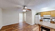 Located at 200 Mt Rushmore Dr in Richmond, Kentucky, this one-bedroom, one-bathroom unit offers a well-designed single-floor layout that makes efficient use of its space. The open living area features rich hardwood-style flooring and a ceiling fan with a light fixture, creating a comfortable and airy atmosphere. Neutral, warm-toned walls throughout give the unit a clean and inviting feel.

The kitchen is a functional highlight, outfitted with warm oak cabinetry, laminate countertops, and white appliances including a refrigerator and electric range. A built-in breakfast bar with seating provides a casual dining option and naturally separates the kitchen from the living area. A window above the sink allows for natural light to brighten the space.

The bedroom is generously proportioned, featuring plush carpeting, a window with blinds for natural light and privacy, a wall-mounted HVAC unit, and two closets offering ample storage. The textured ceiling and soft overhead lighting add to the room's comfortable character.

The bathroom is accessed from the main hallway and includes a wood-toned vanity with under-cabinet storage, a well-lit mirror, and hardwood-style flooring consistent with the rest of the unit. The layout flows logically, making this a practical and comfortable living space.