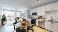 Located at 940 E Adams St in Jacksonville, FL, this thoughtfully designed one-bedroom, one-bathroom residence offers a cohesive and functional single-floor layout. Light-toned walls and warm wood-style flooring flow throughout, creating a bright and welcoming atmosphere.

The living room serves as the heart of the home, featuring a ceiling fan, floor-to-ceiling drapes, and sliding glass doors that open to a private balcony, filling the space with natural light and outdoor views. The kitchen is well-equipped with white cabinetry, granite-style countertops, a classic subway tile backsplash, and a full suite of stainless steel appliances. An adjacent dining area provides room for a full dining table, making the kitchen and dining zone ideal for both everyday meals and entertaining.

The bedroom is a comfortable retreat, featuring a ceiling fan, multiple windows with natural light, and a sliding barn door for added character. The bathroom is finished with a glass-enclosed walk-in shower, wood-look flooring, a granite-topped vanity, and white cabinetry offering ample storage. A dedicated laundry area with a stacked washer and dryer adds everyday convenience, completing this efficiently designed and stylish residence.