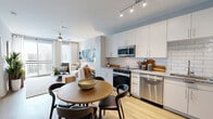 Located at 940 E Adams St in Jacksonville, FL, this thoughtfully designed one-bedroom, one-bathroom residence offers a cohesive and functional single-floor layout. Light-toned walls and warm wood-style flooring flow throughout, creating a bright and welcoming atmosphere.

The living room serves as the heart of the home, featuring a ceiling fan, floor-to-ceiling drapes, and sliding glass doors that open to a private balcony, filling the space with natural light and outdoor views. The kitchen is well-equipped with white cabinetry, granite-style countertops, a classic subway tile backsplash, and a full suite of stainless steel appliances. An adjacent dining area provides room for a full dining table, making the kitchen and dining zone ideal for both everyday meals and entertaining.

The bedroom is a comfortable retreat, featuring a ceiling fan, multiple windows with natural light, and a sliding barn door for added character. The bathroom is finished with a glass-enclosed walk-in shower, wood-look flooring, a granite-topped vanity, and white cabinetry offering ample storage. A dedicated laundry area with a stacked washer and dryer adds everyday convenience, completing this efficiently designed and stylish residence.