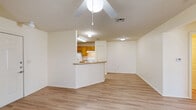 Located at 8301 Tumbleweed Trail in White Settlement, TX, this single-story 2-bedroom, 1-bathroom home offers a practical and comfortable layout. The open-concept living and dining area flows seamlessly into the kitchen, which features warm honey-toned wood cabinetry, a peninsula breakfast bar with laminate countertops, and white appliances including a refrigerator, range, and dishwasher. Light wood-look flooring runs throughout the main living areas, complemented by ceiling fans that add both style and function.

The two bedrooms are carpeted for added comfort, each equipped with a ceiling fan and closet storage. The primary bedroom benefits from natural light through multiple windows with blinds and includes a dedicated closet with built-in shelving. The second bedroom also features carpeted flooring and a ceiling fan. A hallway connects the sleeping quarters to the full bathroom, which includes a tub/shower combination and overhead cabinetry for storage.

The home's neutral color palette of whites and warm beiges creates a clean, inviting atmosphere throughout. A connecting hallway provides easy access between all rooms, rounding out an efficient and well-organized floor plan suited for comfortable everyday living.
