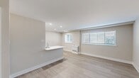 Located at 7949 Ridge Ave in Philadelphia's Roxborough neighborhood, this one-bedroom, one-bathroom unit offers a thoughtfully designed single-floor layout with contemporary finishes throughout. The open-concept kitchen and living area serves as the heart of the space, featuring light wood-style flooring, recessed lighting, and a neutral color palette that creates a bright, airy atmosphere. The kitchen is appointed with two-tone cabinetry — crisp white upper cabinets paired with rich dark lower cabinets — complemented by a subway tile backsplash, a white quartz peninsula with an undermount sink, and a full suite of stainless steel appliances including a gas range, dishwasher, microwave, and refrigerator. The living area provides an open and flexible space with ample room for various furniture arrangements. An entry foyer with light wood-style flooring connects the main living spaces and offers access to additional rooms. The generously sized bedroom features soft carpeting, a built-in closet, and a window overlooking the outdoors, bringing in natural light. The bathroom is finished with large-format neutral tile and includes a spacious walk-in shower with a sliding glass enclosure, a built-in bench, and a modern vanity.