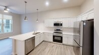This 640 square foot apartment in Cedar Rapids, Iowa, offers a blend of comfort and functionality. The space comprises two bedrooms, one bathroom, and an open-concept living area. The primary bedroom, measuring 140 square feet, provides ample space for rest and relaxation. Large windows in the bedrooms allow for natural light and offer city views, enhancing the sense of spaciousness.

The kitchen is a highlight, featuring modern stainless steel appliances, including a refrigerator, stove, microwave, and dishwasher. White cabinetry contrasts nicely with the light wood-look flooring, creating a bright and inviting atmosphere. Pendant lighting adds a touch of style to the space.

The bathroom is efficiently designed, combining practicality with contemporary aesthetics. It includes a bathtub-shower combo and a single vanity. A notable feature is the in-unit laundry area with a stacked washer and dryer, adding convenience to daily life.

Throughout the apartment, neutral tones dominate, providing a blank canvas for personalization. The use of light colors and ample lighting fixtures contributes to a bright and airy ambiance. Built-in closets offer valuable storage solutions, maximizing the use of available space in this compact yet well-designed urban dwelling.